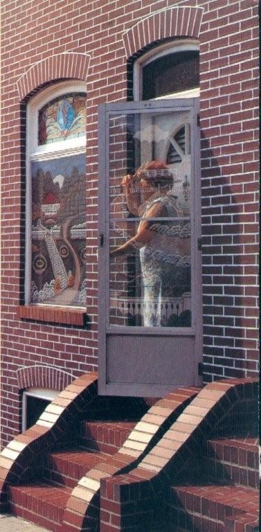 Baltimore rowhouse resident Mrs. Figinski stands inside her painted screen door